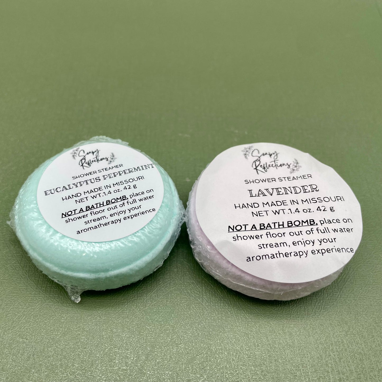 Two shower steamers, one green, one purple.