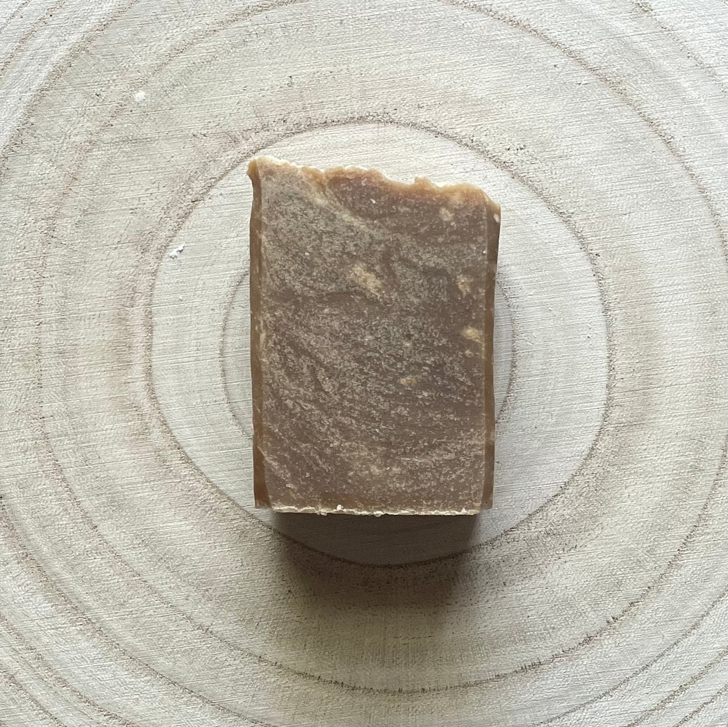 One soap bar, dark brown in color with white specks, pine tar scent.