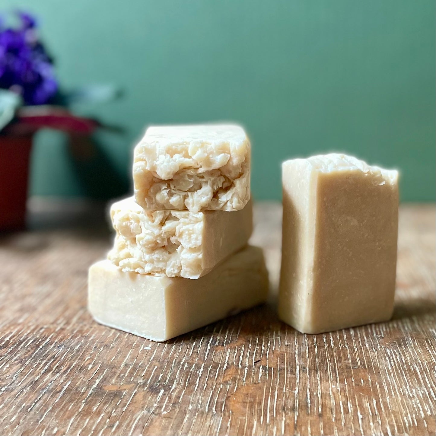 Stack of four soap bars, off white in color with white specks, eucalyptus and spearmint scent.