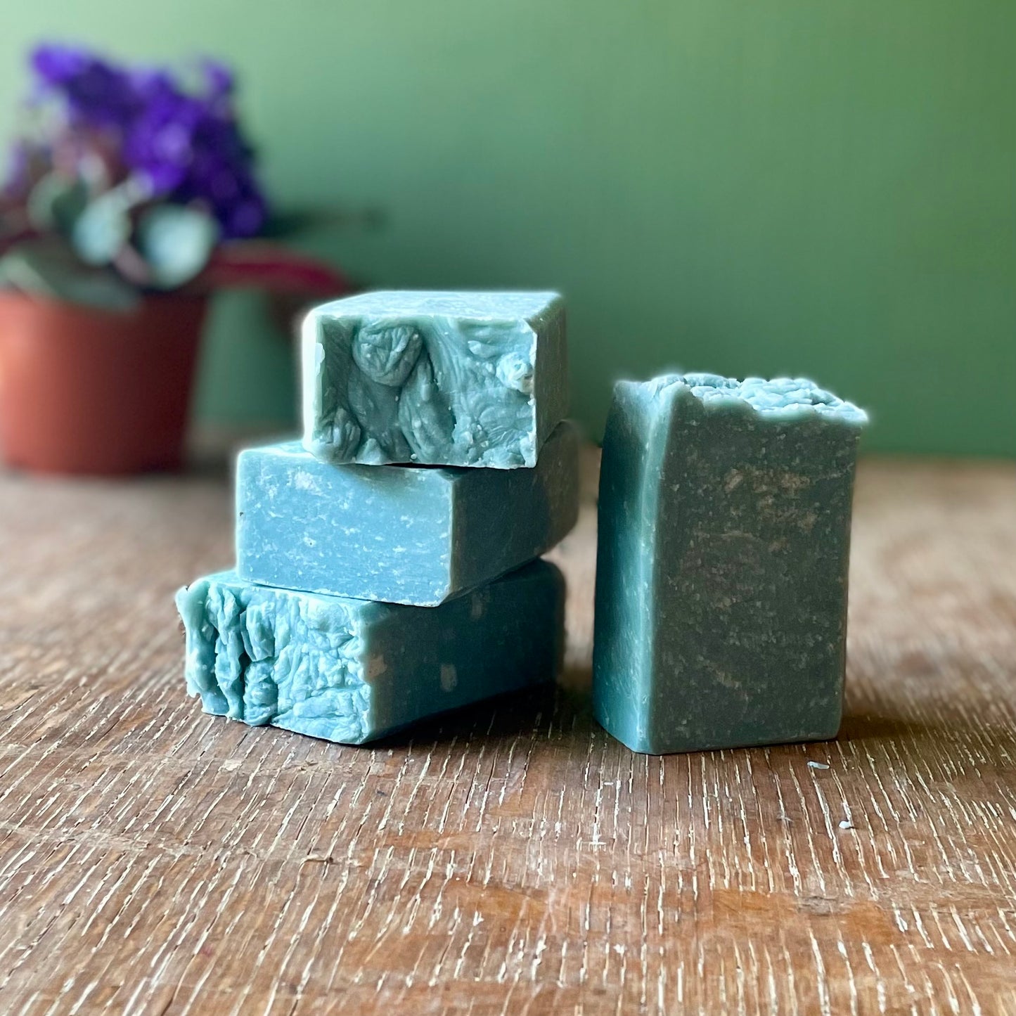 Stack of four bars of soap, medium blue in color with white specks, ocean mist scent.