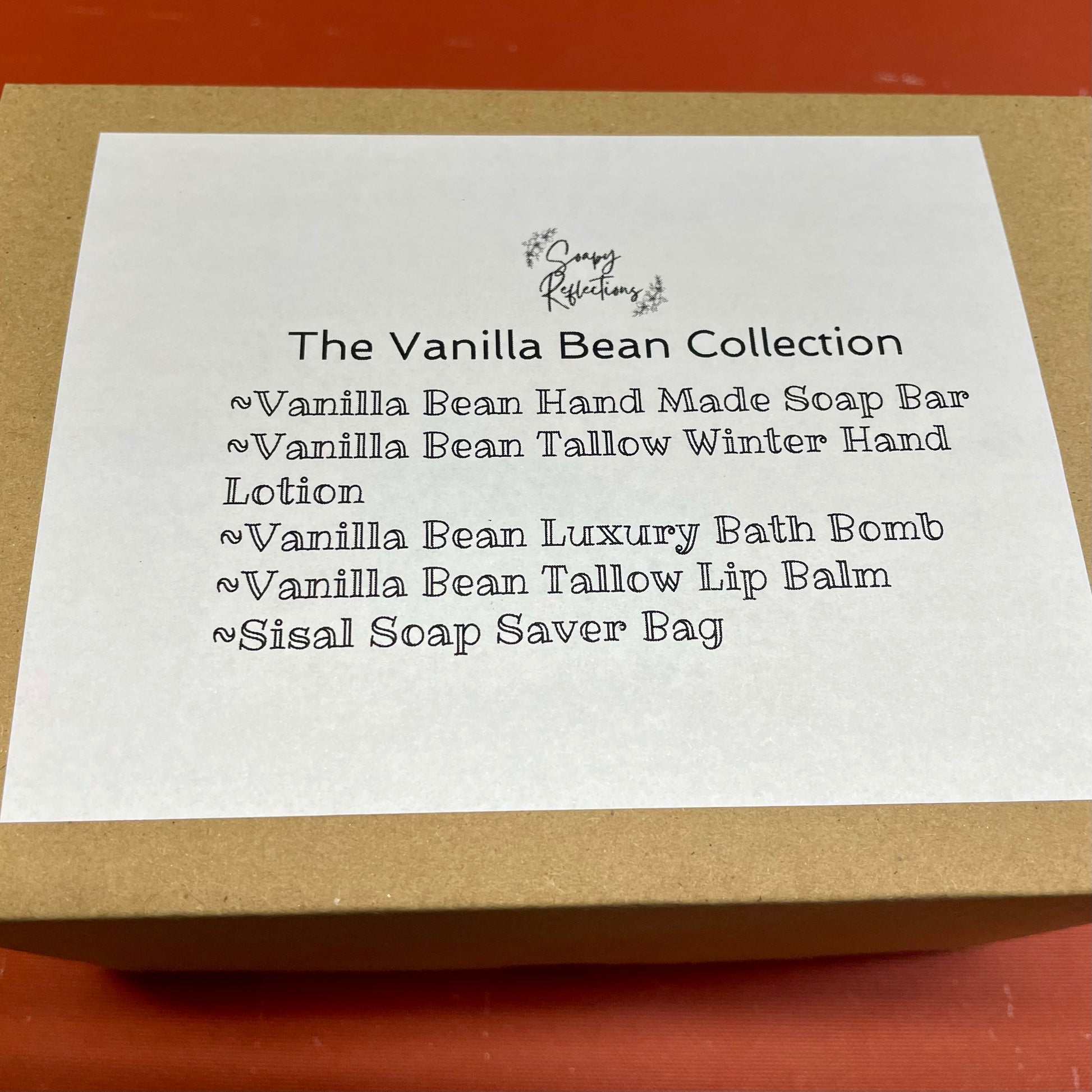 Gift box top label detailing vanilla bean collection, bath bomb, soap bar, lip balm, lotion, sisal bag. 