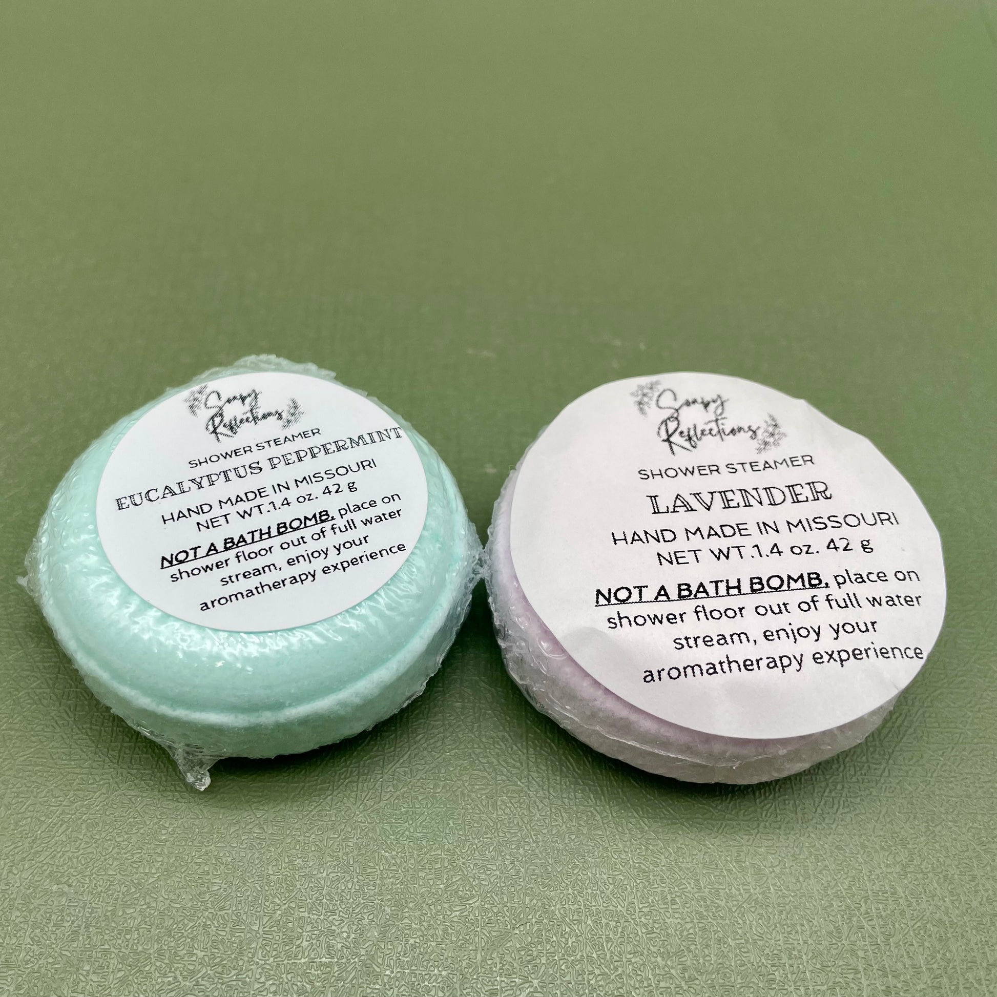 Two shower steamers, one green, one purple.