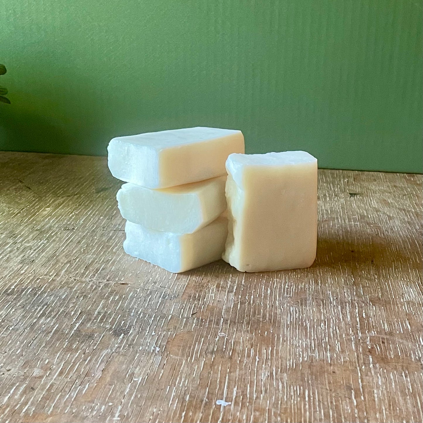 Stack of four soap bars, white in color, unscented.