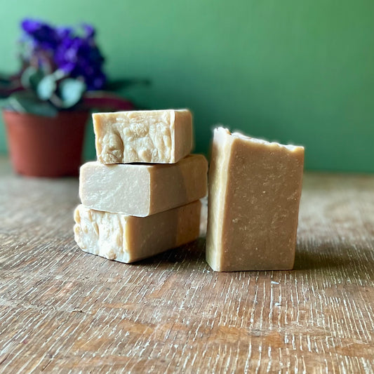 Stack of four bars of soap, tan in color with white speckles, vanilla sugar scent.